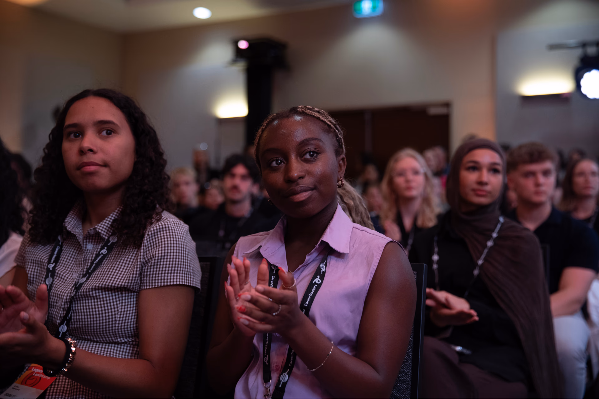 CareerTrackers students seated together in a conference audience, applauding.