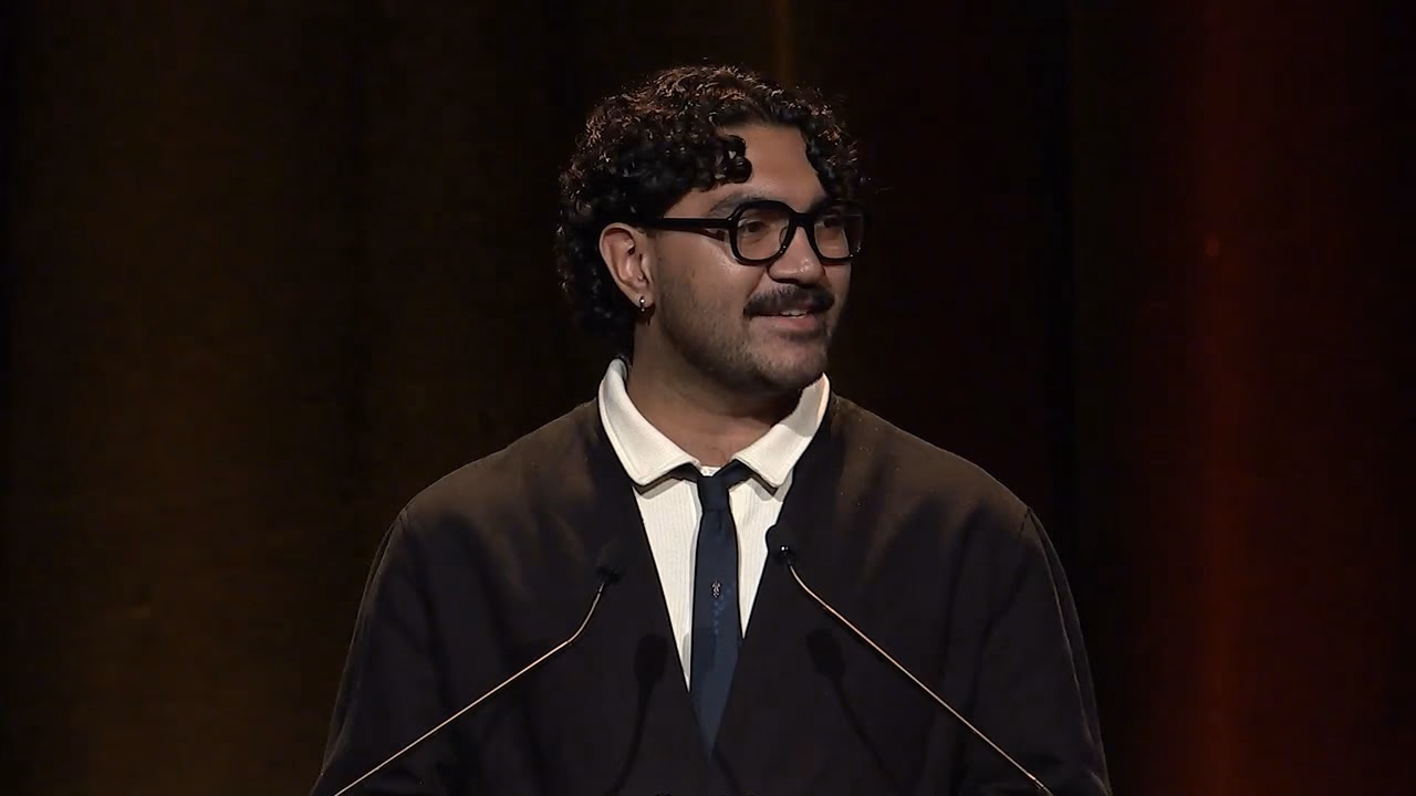 Isaac Gebadi speaking at the lectern at the 2026 National Gala Awards.