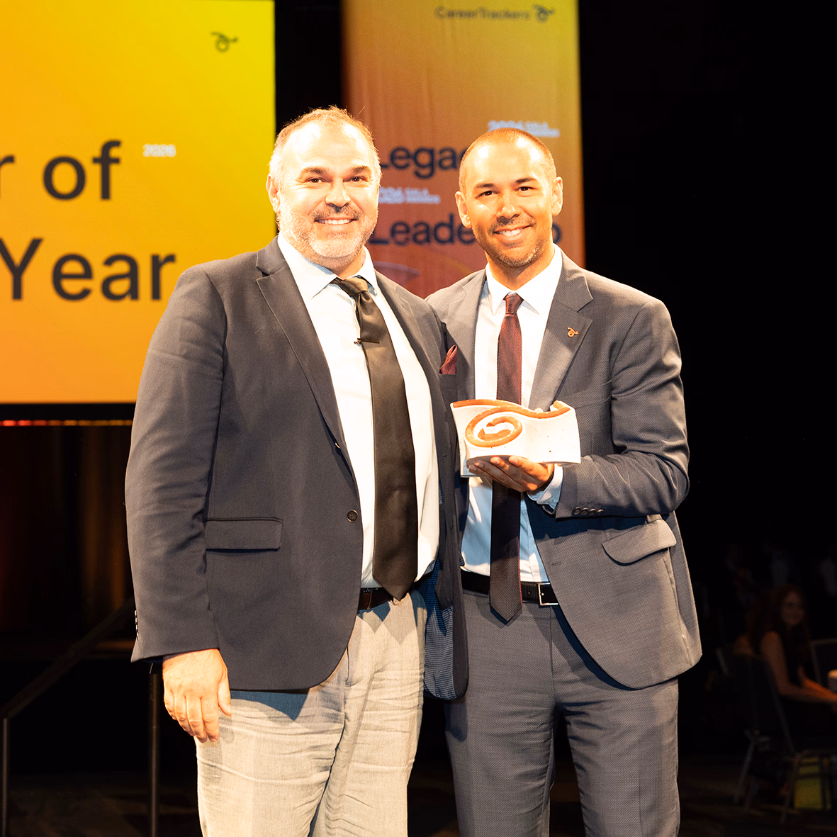 CareerTrackers Gala Awards presenters celebrating on stage with an award.