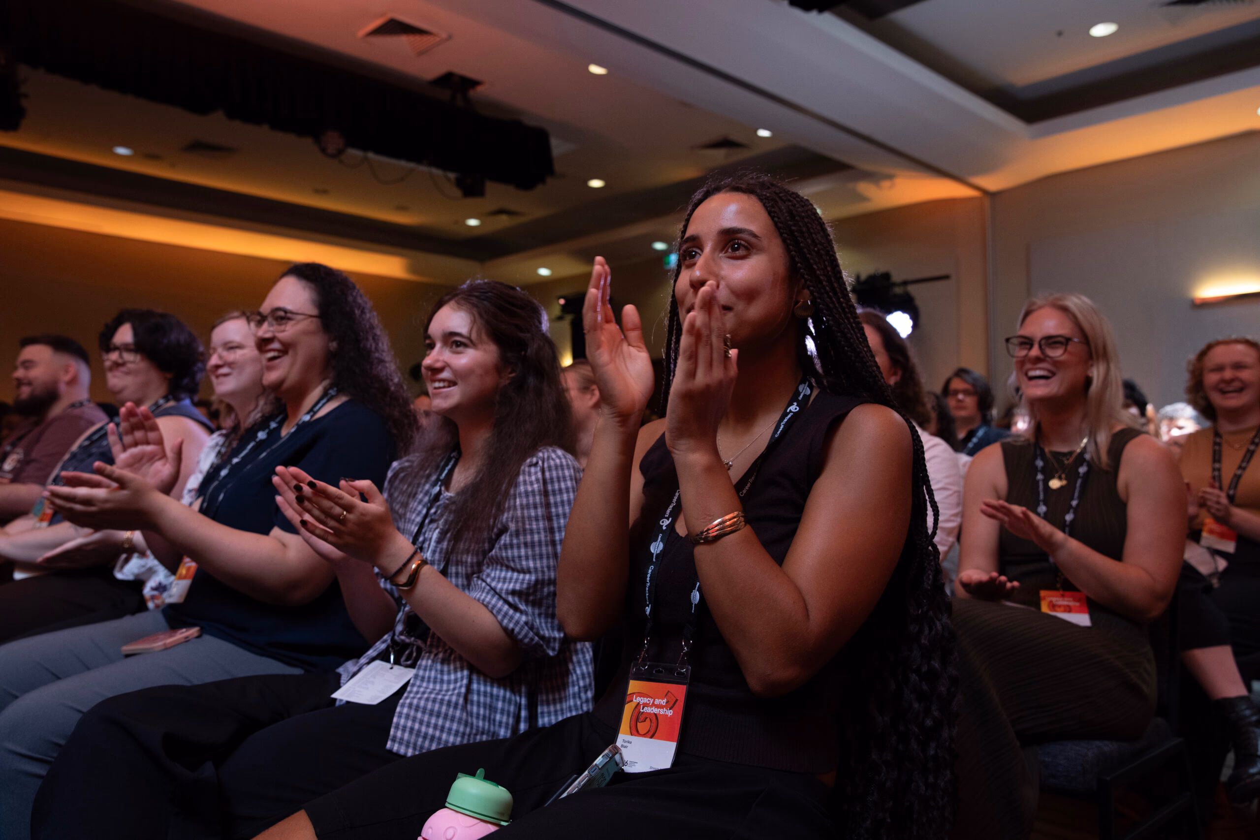 CareerTrackers interns and community members applauding at the Leadership Development Institute conference.